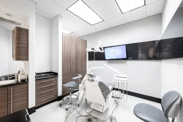 A dental exam room at Torrance Dental Center with wooden cabinets lining the wall beside an exam chair