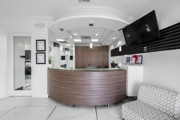 The rounded front desk of Torrance Dental Center in the clinic's marble lobby