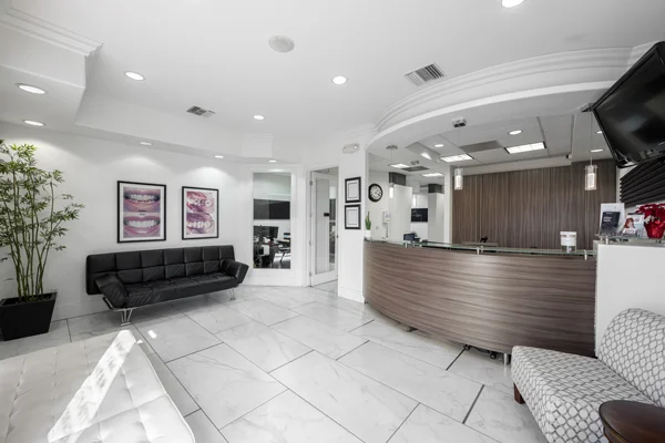The marble-floored lobby of Torrance Dental Center with a wide front desk and comfortable seating